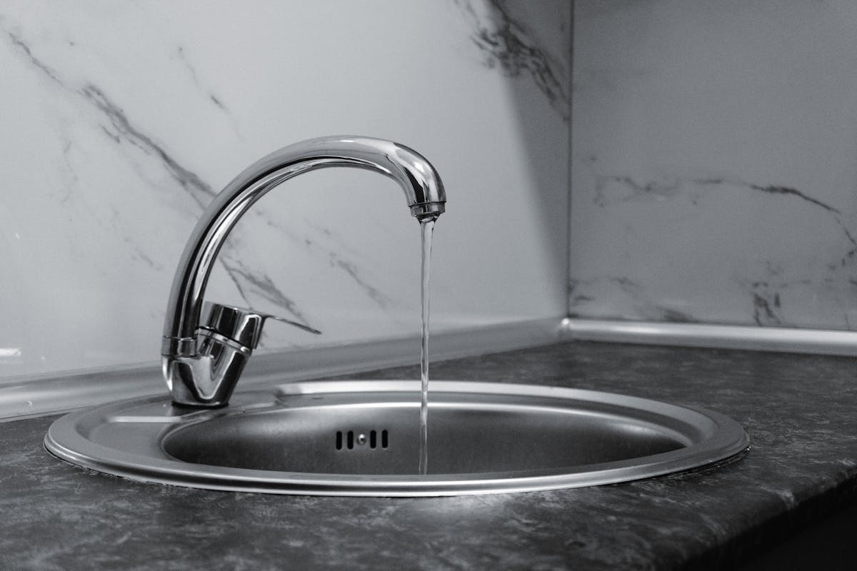 Clean crystal clear water running from kitchen faucet after water softener installation in Livingston County Michigan