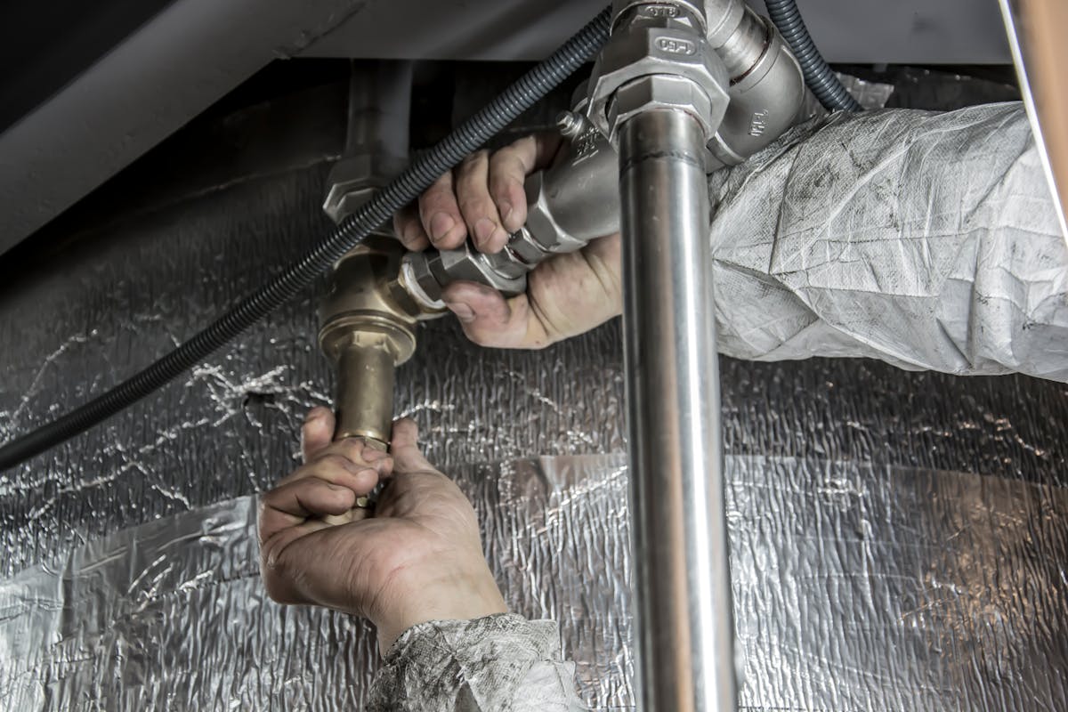 Professional technician installing air induction water filtration system for iron and sulfur removal Michigan